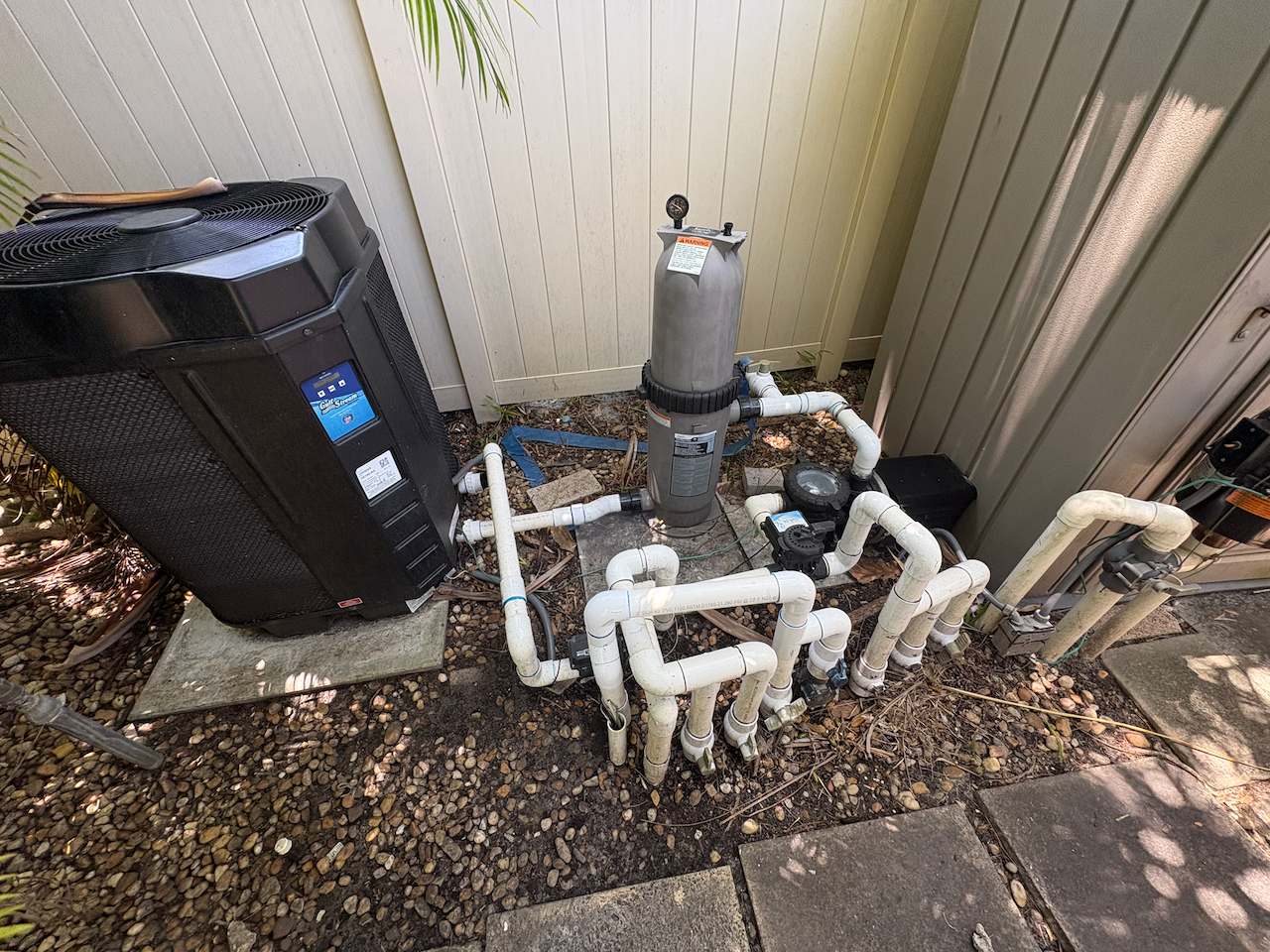 hero-equipment-pad - Downtown Pools Pool equipment pad on a Broward County property, with heat pump, filter and valve plumbing
